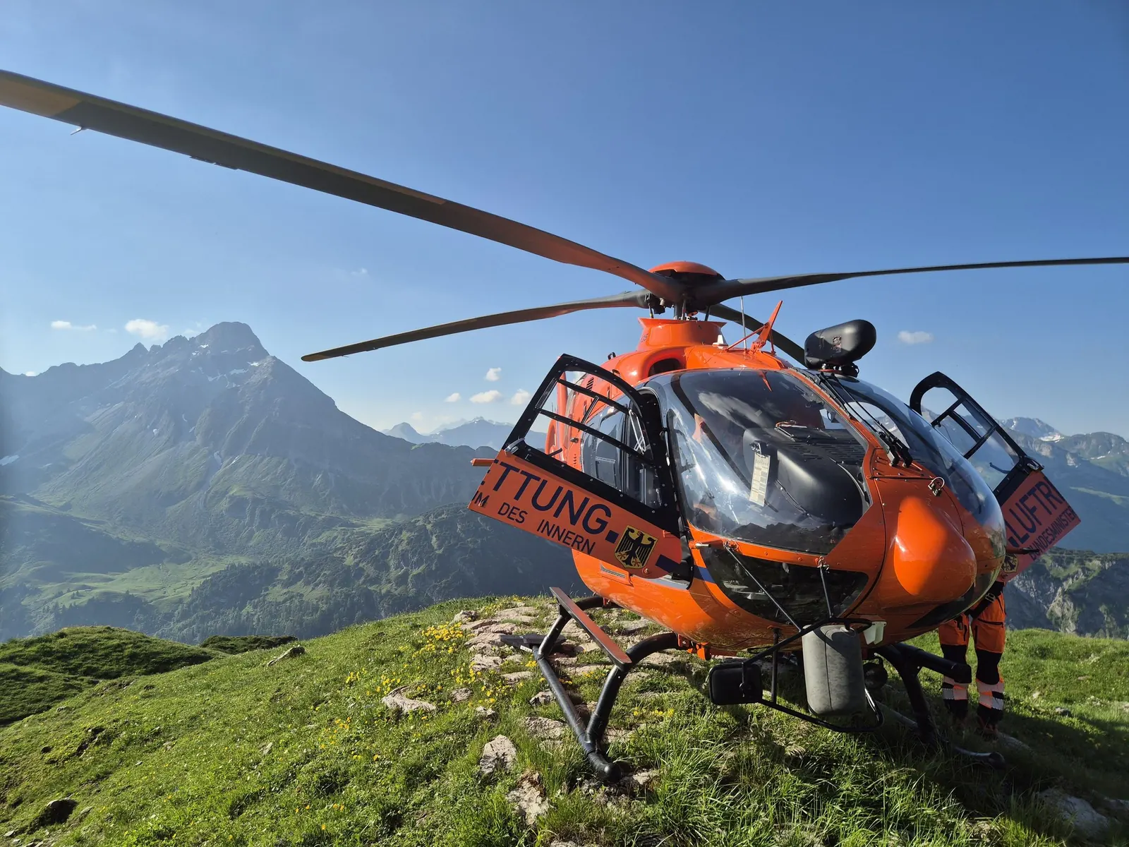 Christoph 17 gelandet auf einer Alm vor einem Gipfel